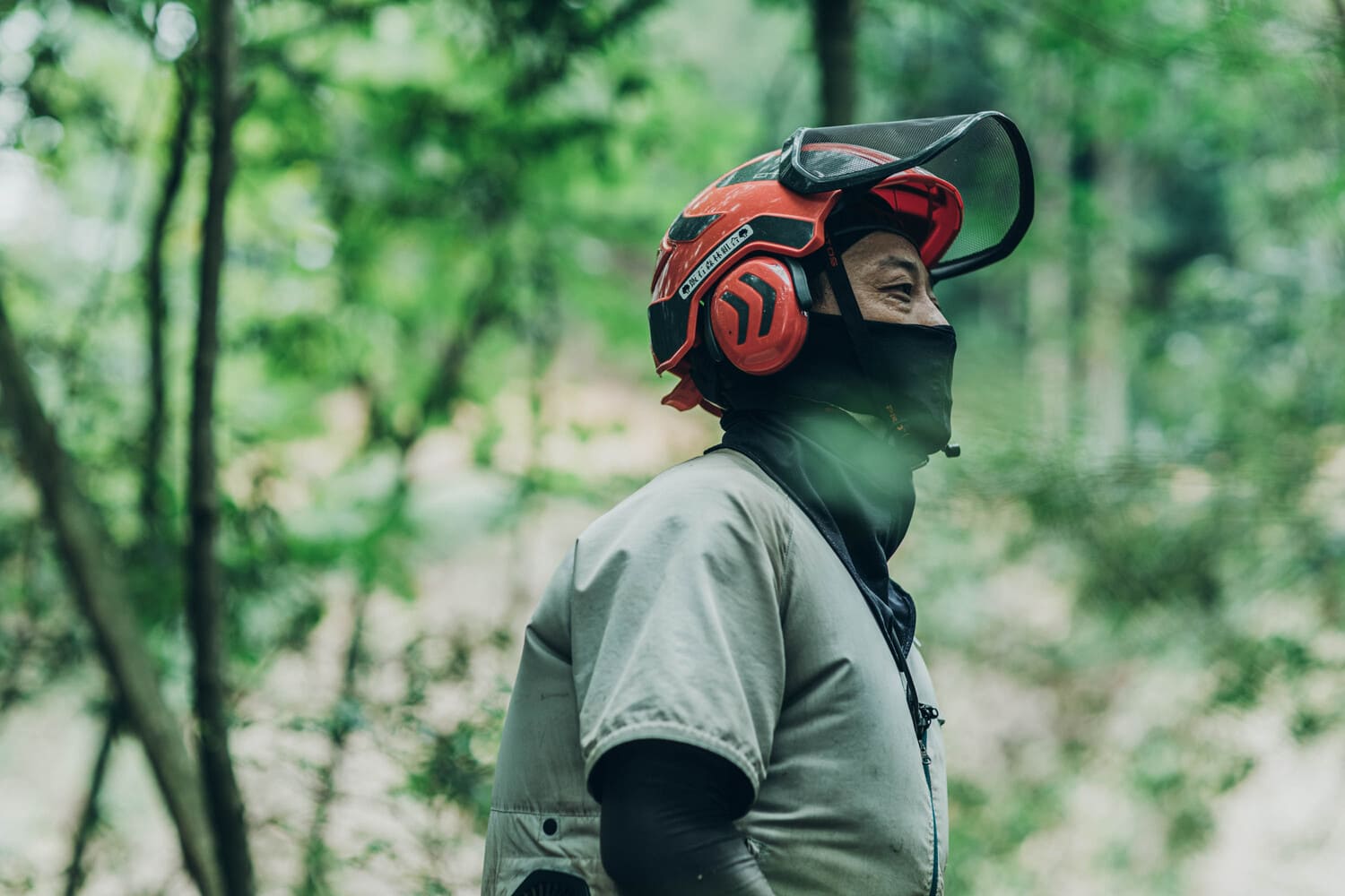 林業従事者の男性。赤いヘルメットをかぶっている。